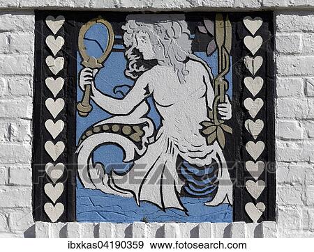Stock Photo - Mermaid looks in the mirror, sgraffito on a villa from 1926, historic uptown de Concessie, seaside resort De Haan, West Flanders, Belgium, Europe. Fotosearch