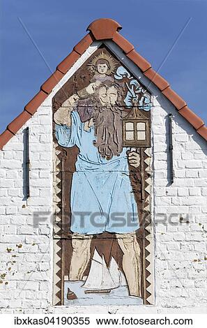 Stock Photography - Saint Christopher, figure made of ceramic tiles on a villa from 1926, historic uptown de Concessie, seaside resort De Haan, West Flanders, Belgium, Europe. Fotosearch