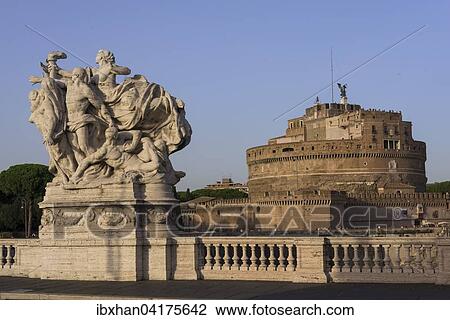 Stock Image - Sculpture on the bridge Ponte Vittorio Emanuele II, Castel Sant'Angelo behind, Rome, Lazio, Italy, Europe. Fotosearch