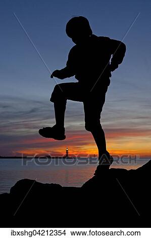 Picture - Silhouette of a boy at sunset, Warnemunde, Mecklenburg-Western Pomerania, Germany, Europe. Fotosearch