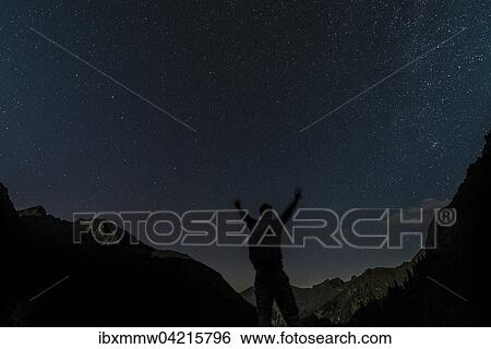 Stock Photograph - Silhouette of person looking at the stars, starry sky at night, Rohrmoos-Untertal, Schladming Tauern, Alps, Styria, Austria, Europe. Fotosearch