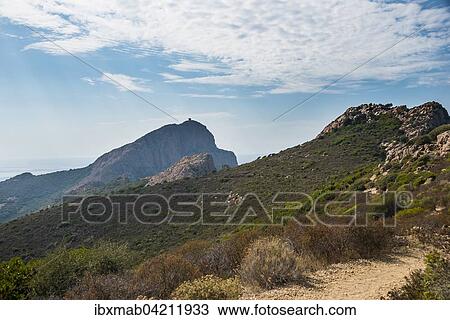 Stock Image - Trail with Genoese tower behind, coastal and mountain scenery, Gulf of Porto, Corsica, France, Europe. Fotosearch