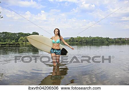 Young woman with a surfing board, outdoor, near Coburg, Bavaria, Germany, Europe View Large Photo Image Stock Photograph - Young woman with a surfing board, outdoor, near Coburg, Bavaria, Germany, Europe. Fotosearch