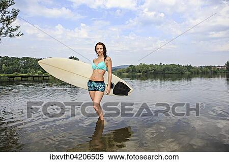 Young woman with a surfing board, outdoor, near Coburg, Bavaria, Germany, Europe View Large Photo Image Stock Photography - Young woman with a surfing board, outdoor, near Coburg, Bavaria, Germany, Europe. Fotosearch