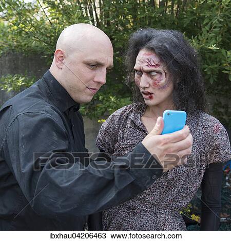 Zombie and man with smartphone, film shoot, scene from a zombie comedy, short film Brain Freeze View Large Photo Image Stock Image - Zombie and man with smartphone, film shoot, scene from a zombie comedy, short film Brain Freeze. Fotosearch