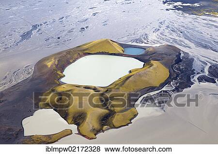 Stock Photo - Aerial view of a volcano, moss and red minerals on the slopes shining in the sunlight, the extinct craters are filled with coloured water, the volcano is located between the waterways of the Tungna River and Lake Langisjoer, between Landmannalaugar.... Fotosearch