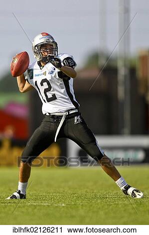 Stock Image - American Football, QB Philipp Brugger, No. 12 of the Raiders, passing the ball on; Kornmesser Rangers win Silver Bowl XIV against the Swarco Raiders II 41: 10, Vienna, Austria, Europe. Fotosearch
