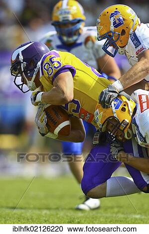 Stock Image - American Football, WR Valentin Schulz, No. 85 of the Vikings, being tackled; Vienna Vikings win against Graz Giants 19: 14, Vienna, Austria, Europe. Fotosearch