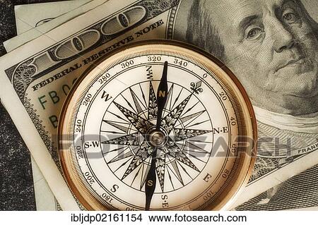Picture - Antique gold compass on an array of US dollars, symbolic image for financial planning. Fotosearch