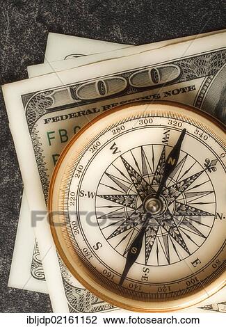 Antique gold compass on an array of US dollars, symbolic image for financial planning View Large Photo Image Stock Image - Antique gold compass on an array of US dollars, symbolic image for financial planning. Fotosearch
