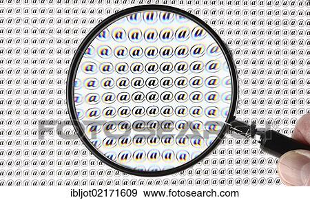Stock Photo - At symbol, @, through a magnifying glass. Fotosearch