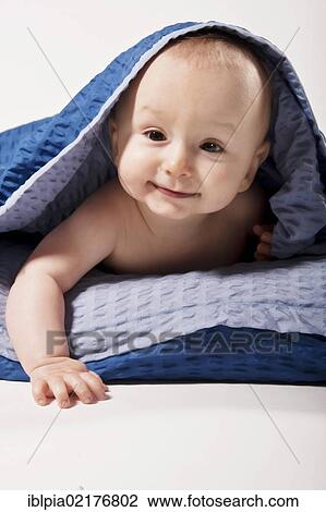 Stock Image - Baby boy, 8 months, under a blanket. Fotosearch