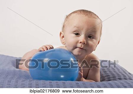 Stock Photo - Baby boy, 8 months, with a balloon. Fotosearch