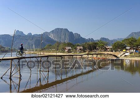 Stock Photo - Bamboo bridge over the Nam Song River, karst mountains, Vang Vieng, Vientiane, Laos, Indochina, Asia. Fotosearch