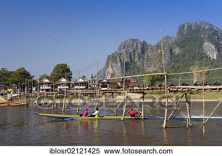 Stock Photography - Bamboo bridge over the Nam Song River, karst mountains, Vang Vieng, Vientiane, Laos, Indochina, Asia. Fotosearch