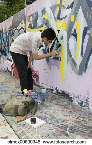 Boy spraying graffiti on a wall in Singapore, Southeast Asia View Large Photo Image Stock Photograph - Boy spraying graffiti on a wall in Singapore, Southeast Asia. Fotosearch