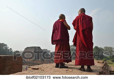 Stock Image - Buddhism, Tibetan monks wearing red robes during a pilgrimage to the archaeological site of the ancient university of Nalanda, Global Buddhist Congregation 2011, Ragir, Bihar, India, Asia. Fotosearch