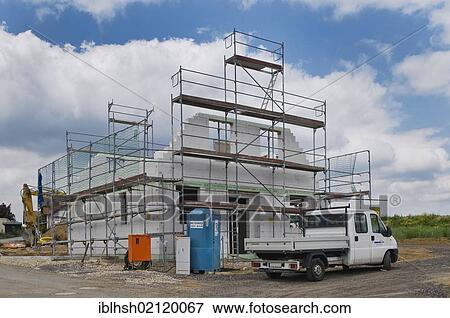 Building site, scaffolded bare brickwork, privately owned home, transporter, electrical connection and portable toilet in front of it, PublicGround View Large Photo Image Stock Photo - Building site, scaffolded bare brickwork, privately owned home, transporter, electrical connection and portable toilet in front of it, PublicGround. Fotosearch