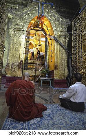 Burmese monk and a devout elderly man sitting in prayer in front of the most holy Buddha statue of the country, the golden Mahamuni Buddha is covered in gold leaf by believers, Mandalay, Burma, Myanmar, Southeast Asia, Asia View Large Photo Image Stock Photo - Burmese monk and a devout elderly man sitting in prayer in front of the most holy Buddha statue of the country, the golden Mahamuni Buddha is covered in gold leaf by believers, Mandalay, Burma, Myanmar, Southeast Asia, Asia. Fotosearch