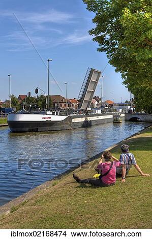 Cargo shipping passing a movable bridge, Vlaanderen Fietsroute, Flanders Bike Trail, at the Coupure Canal, Bruges, West Flanders, Flemish Region, Belgium, Europe View Large Photo Image Picture - Cargo shipping passing a movable bridge, Vlaanderen Fietsroute, Flanders Bike Trail, at the Coupure Canal, Bruges, West Flanders, Flemish Region, Belgium, Europe. Fotosearch