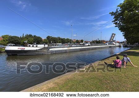 Cargo shipping passing a movable bridge, Vlaanderen Fietsroute, Flanders Bike Trail, at the Coupure Canal, Bruges, West Flanders, Flemish Region, Belgium, Europe View Large Photo Image Stock Image - Cargo shipping passing a movable bridge, Vlaanderen Fietsroute, Flanders Bike Trail, at the Coupure Canal, Bruges, West Flanders, Flemish Region, Belgium, Europe. Fotosearch