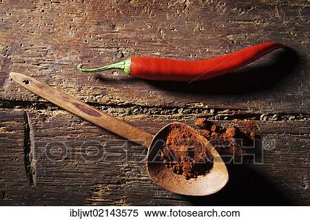 Chili Pepper (Capsicum) with a wooden spoon and chili powder on a rustic wooden surface View Large Photo Image Stock Photography - Chili Pepper (Capsicum) with a wooden spoon and chili powder on a rustic wooden surface. Fotosearch