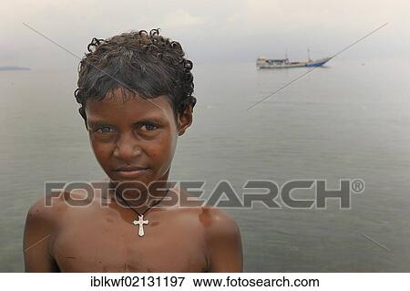 Christian Papua boy wearing a cross on a necklace while bathing in Kota Biak, Biak Island, Irian Jaya, Indonesia, Southeast Asia, Asia View Large Photo Image Stock Photo - Christian Papua boy wearing a cross on a necklace while bathing in Kota Biak, Biak Island, Irian Jaya, Indonesia, Southeast Asia, Asia. Fotosearch