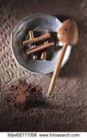 Cinnamon sticks (Cinnamomum) on a metal plate with a wooden spoon and cinnamon powder on a rustic stone base View Large Photo Image Stock Photo - Cinnamon sticks (Cinnamomum) on a metal plate with a wooden spoon and cinnamon powder on a rustic stone base. Fotosearch