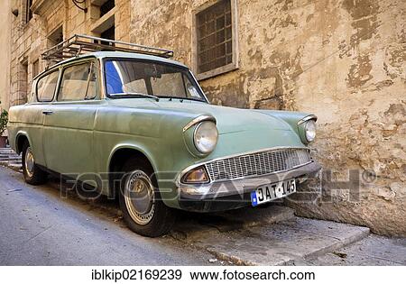 Stock Photo - Classic Ford Anglia parked in a narrow street in Valletta, Malta, Europe. Fotosearch