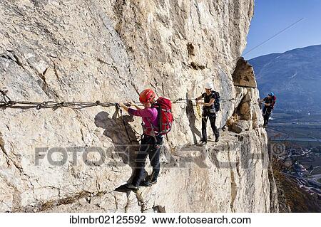 Stock Image - Climbers ascending Monte Albano along the fixed climbing route above Mori, Lake Garda Mountains, Rovereto, Trento, Italy, Europe. Fotosearch