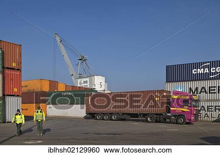 Container handling in the port of Bonn, truck with a container trailer in front of a crane, workers walking through the terminal, Bonn, North Rhine-Westphalia, Germany, Europe View Large Photo Image Stock Image - Container handling in the port of Bonn, truck with a container trailer in front of a crane, workers walking through the terminal, Bonn, North Rhine-Westphalia, Germany, Europe. Fotosearch