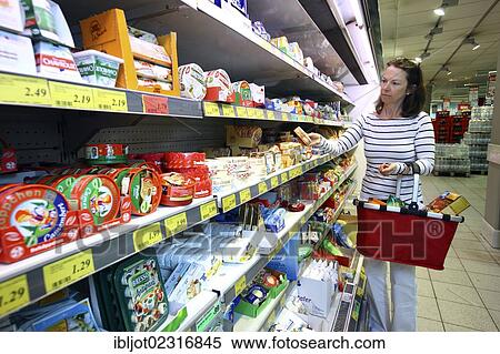 Stock Photography - Cooler, woman shopping for a variety of dairy products, self-service, food department, supermarket, Germany, Europe. Fotosearch