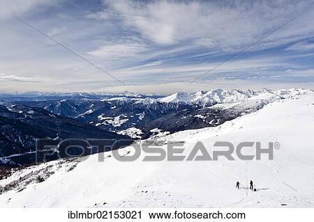 Stock Image - Cross-country skiers ascending Sattele Mountain above Reinwald, overlooking the Sarn Valley, Alto Adige, Italy, Europe. Fotosearch