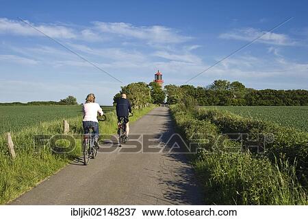 Stock Photo - Cyclists in front of the lighthouse on the coastal cliffs of Staberhuk, Fehmarn Island, Baltic Sea, Schleswig-Holstein, Germany, Europe. Fotosearch