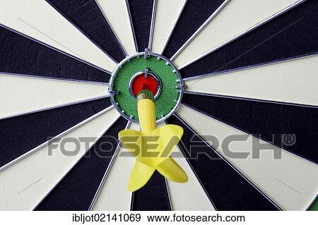Stock Photo - Darts, throwing game, dart sticking into the middle of the dartboard, the bullseye. Fotosearch