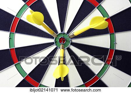 Stock Image - Darts, throwing game, darts sticking into the middle of the dartboard, the bullseye. Fotosearch