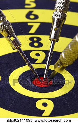 Stock Photography - Darts, throwing game, darts sticking into the middle of the dartboard, the bullseye. Fotosearch