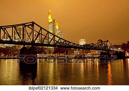 Eiserner Steg Bruecke, bridge over the Main river with the illuminated skyline of Frankfurt at dusk, Frankfurt am Main, Hesse, Germany, Europe View Large Photo Image Picture - Eiserner Steg Bruecke, bridge over the Main river with the illuminated skyline of Frankfurt at dusk, Frankfurt am Main, Hesse, Germany, Europe. Fotosearch