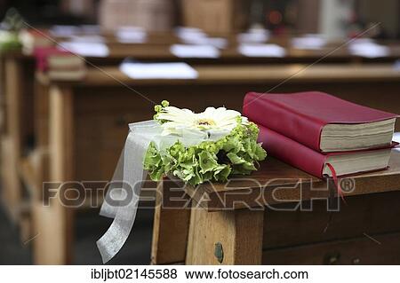Stock Photo - Floral arrangement and prayer hymnbooks, decorations in a church for a church wedding. Fotosearch