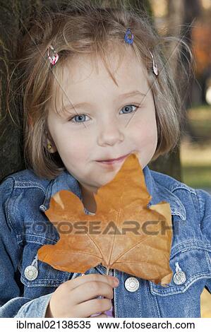 Girl, 4, in autumn holding a leaf in her hand View Large Photo Image Stock Photography - Girl, 4, in autumn holding a leaf in her hand. Fotosearch