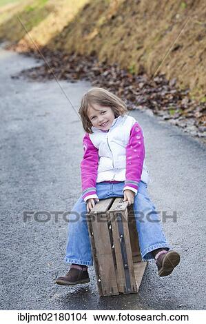 Girl, 4, sitting on a wooden crate View Large Photo Image Picture - Girl, 4, sitting on a wooden crate. Fotosearch