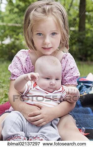 Girl, 4, with a baby in her arms View Large Photo Image Stock Photo - Girl, 4, with a baby in her arms. Fotosearch