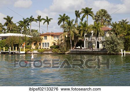Girl on a surfboard off luxury mansions in Miami, Florida, USA, North America View Large Photo Image Stock Photograph - Girl on a surfboard off luxury mansions in Miami, Florida, USA, North America. Fotosearch