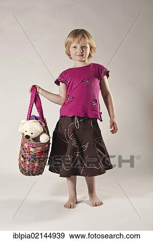 Stock Photo - Girls, 5, carrying a teddy bear in a bag. Fotosearch