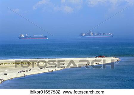 Headland with people where the North Sea and the Baltic Sea meet, container ships at back, Skagen, Jutland, Denmark, Europe View Large Photo Image Stock Image - Headland with people where the North Sea and the Baltic Sea meet, container ships at back, Skagen, Jutland, Denmark, Europe. Fotosearch