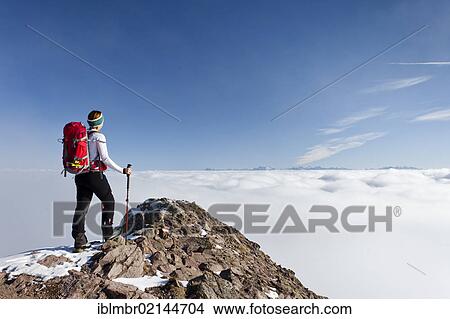 Picture - Hiker ascending Grosse Laugenspitze Mountain above Laugenalm alpine pasture, overlooking the Dolomites, Gampen Pass, Alto Adige, Italy, Europe. Fotosearch