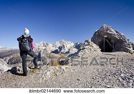 Stock Image - Hiker on Costabela Mountain while using the Bepi Zac climbing route in San Pellegrino Valley above San Pellegrino Pass, overlooking Marmolada Mountain, Dolomites, Trentino, Italy, Europe. Fotosearch