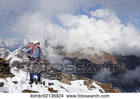 Hiker on Lorcherspitz Mountain above Gruensee Lake, with Weissbrunnspitze und Zufrittspitze Mountains in high fog at the rear, Alto Adige, Italy, Europe View Large Photo Image Picture - Hiker on Lorcherspitz Mountain above Gruensee Lake, with Weissbrunnspitze und Zufrittspitze Mountains in high fog at the rear, Alto Adige, Italy, Europe. Fotosearch
