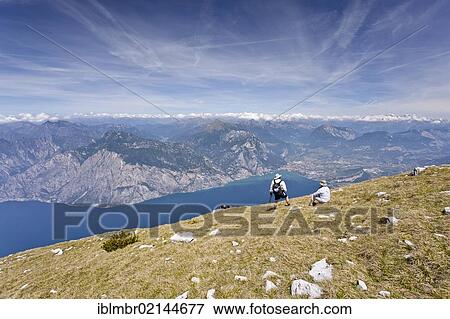 Stock Photo - Hikers on Monte Altissimo above Nago, overlooking Lake Garda and Arco, Trentino, Italy, Europe. Fotosearch