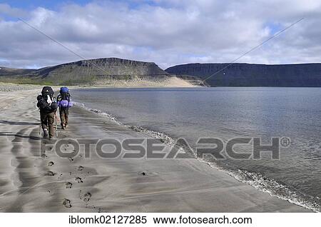 Stock Photography - Hikers walking on the beach, Aðalvík Bay, Adalvik, Hornstrandir, Westfjords, Iceland, Europe. Fotosearch